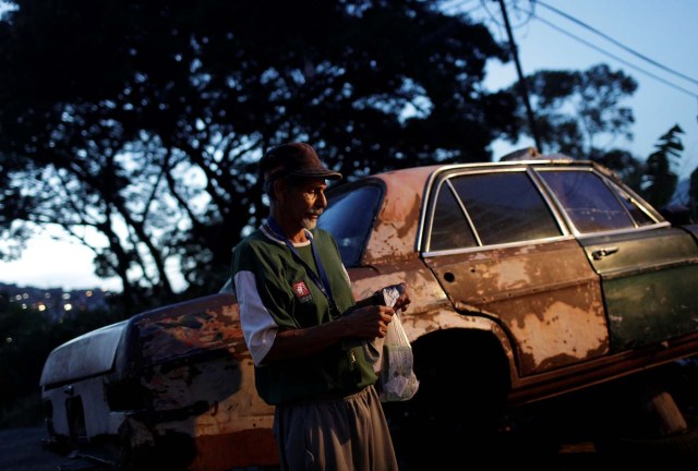 Eduardo Liendo, 63, who lives inside an old car, holds his prize money which he won on "Los Animalitos" (or the Little Animals) betting game on the outskirts of Caracas, Venezuela, October 11, 2017. REUTERS/Ricardo Moraes SEARCH "MORAES GAMBLING" FOR THIS STORY. SEARCH "WIDER IMAGE" FOR ALL STORIES.