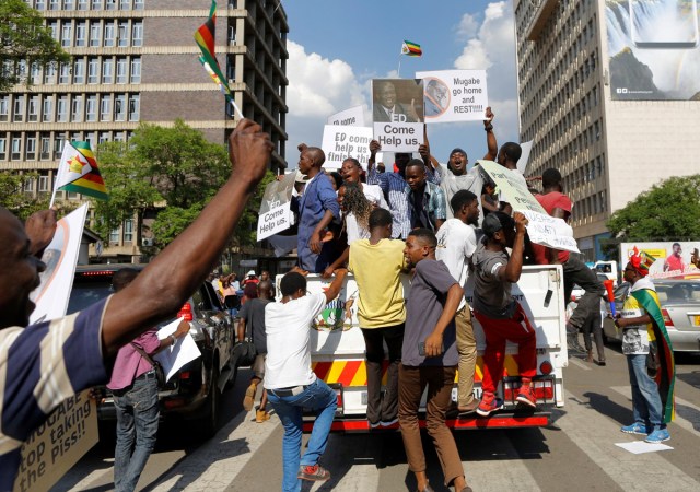 EPA3247. HARARE (ZIMBABWE), 21/11/2017.- Manifestantes protestan en las inmediaciones del Parlamento en Harare (Zimbabue) hoy, 21 de noviembre de 2017. El Parlamento celebra hoy una sesión para tratar una moción de censura contra el presidente, Robert Mugabe. EFE/ Kim Ludbrook