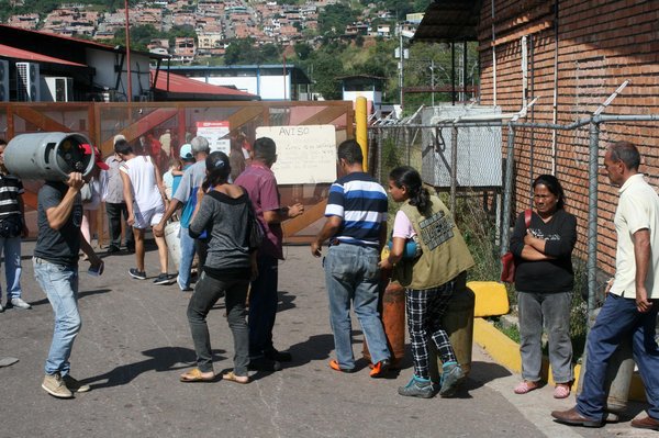 Mujeres y hombres soportan tediosas horas de espera para lograr adquirir una bombona de gas. (foto Tulia Buriticá)
