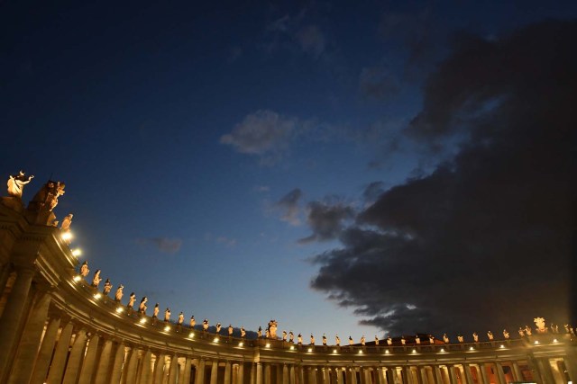 The colonnade is illuminated during the inauguration at night of the christmas crib of St Peter's square on December 7, 2017 in Vatican. / AFP PHOTO / Alberto PIZZOLI