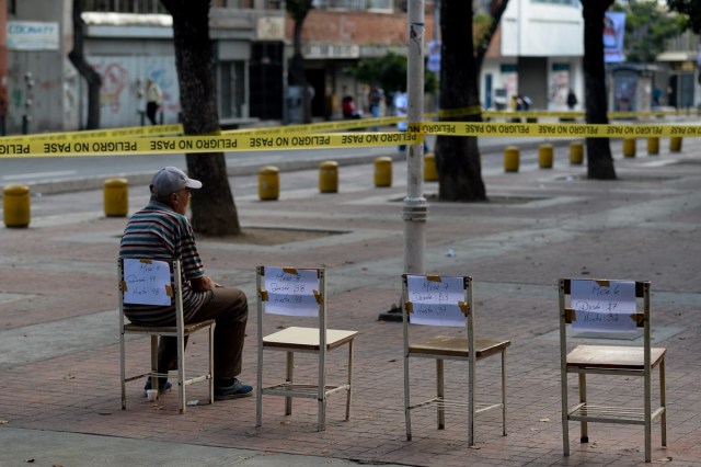 A man waits outside a polling station to cast his vote during municipal elections in Caracas on December 10, 2017. / AFP PHOTO / FEDERICO PARRA