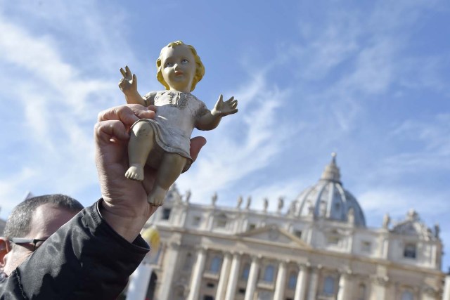 A person holds a figurine of Baby Jesus in direction of Pope Francis during the traditional benediction of the figurines as part of the Sunday Angelus prayer before Christmas, on December 17, 2017 at St Peter's square in Vatican.  / AFP PHOTO / Andreas SOLARO