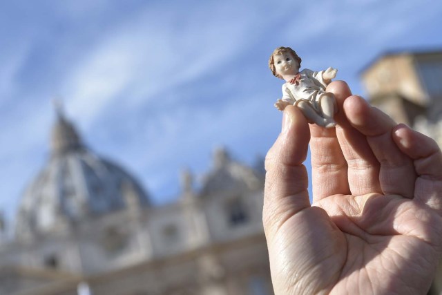 A person holds a figurine of Baby Jesus in direction of Pope Francis during the traditional benediction of the figurines as part of the Sunday Angelus prayer before Christmas, on December 17, 2017 at St Peter's square in Vatican.  / AFP PHOTO / Andreas SOLARO