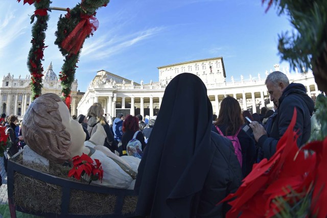 A nun stands by a sculpture of Baby Jesus before the traditional benediction of the figurines as part of the Sunday Angelus prayer before Christmas, on December 17, 2017 at St Peter's square in Vatican.  / AFP PHOTO / Andreas SOLARO