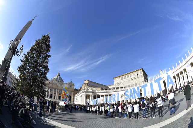 People hold giant letters to form the words "Happy Birthday Holyness" during the Sunday Angelus prayer before Christmas, on December 17, 2017 at St Peter's square in Vatican. Pope Francis celebrates his 81st birthday today on December 17, 2017. / AFP PHOTO / Andreas SOLARO