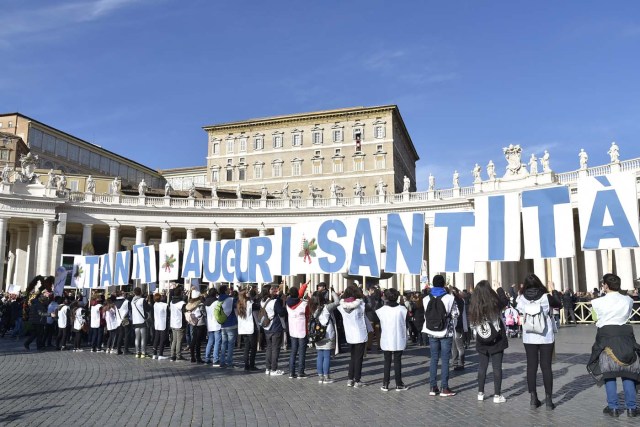 People hold giant letters to form the words "Happy Birthday Holyness" during the Sunday Angelus prayer before Christmas, on December 17, 2017 at St Peter's square in Vatican. Pope Francis celebrates his 81st birthday today on December 17, 2017. / AFP PHOTO / Andreas SOLARO