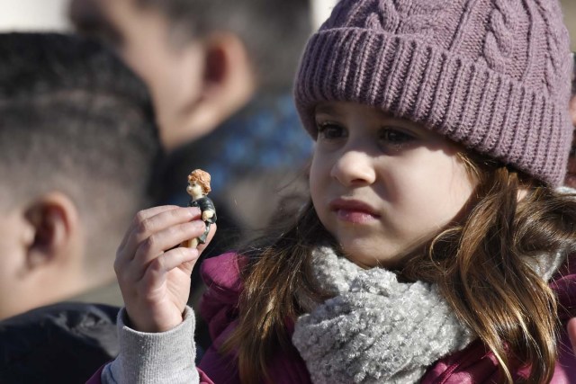 A little girl holds a figurine of Baby Jesus in direction of Pope Francis during the traditional benediction of the figurines as part of the Sunday Angelus prayer before Christmas, on December 17, 2017 at St Peter's square in Vatican.  / AFP PHOTO / Andreas SOLARO