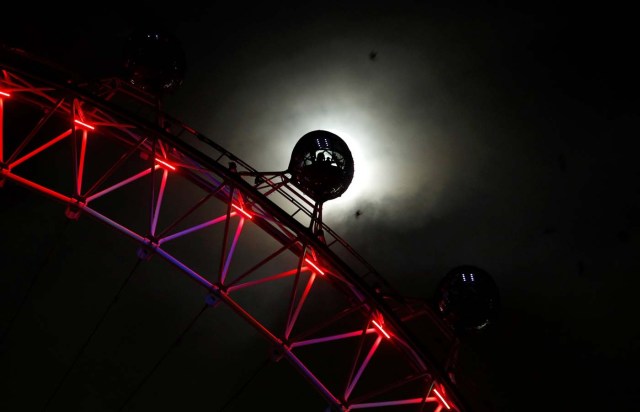 The moon rises behind a pod on the London Eye, lit in red for World AIDS Day, in London, Britain, December 1, 2017. REUTERS/Peter Nicholls TPX IMAGES OF THE DAY