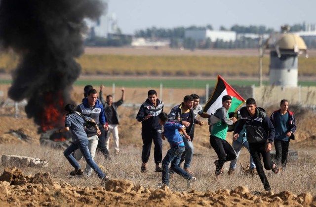 Palestinian protesters run during clashes as Palestinians call for a "day of rage" in response to U.S. President Donald Trump's recognition of Jerusalem as Israel's capital, near the border with Israel in the southern Gaza Strip December 8, 2017. REUTERS/Ibraheem Abu Mustafa