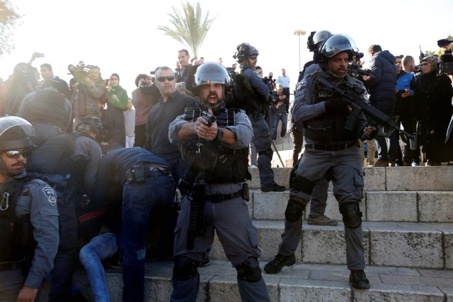 An Israeli policeman aims his weapon as his comrades detain a Palestinian during scuffles at Damascus Gate after Friday prayers in Jerusalem's Old City, as Palestinians call for a "day of rage" in response to U.S. President Donald Trump's recognition of Jerusalem as Israel's capital December 8, 2017. REUTERS/Baz Ratner