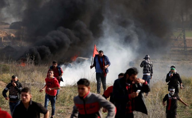 Palestinian protesters run for cover during clashes with Israeli troops as Palestinians call for a "day of rage" in response to U.S. President Donald Trump's recognition of Jerusalem as Israel's capital, near the border with Israel in the east of Gaza City December 8, 2017. REUTERS/Mohammed Salem