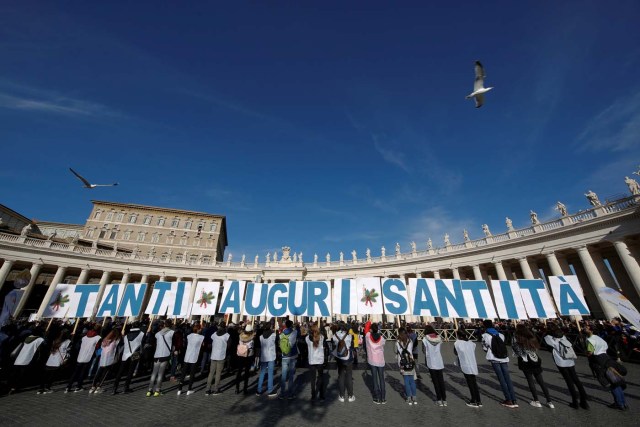 People hold placards reading "Best wishes Holiness" as Pope Francis leads his Sunday Angelus prayer, on the day of his birthday, in Saint Peter's square at the Vatican December 17, 2017. REUTERS/Tony Gentile