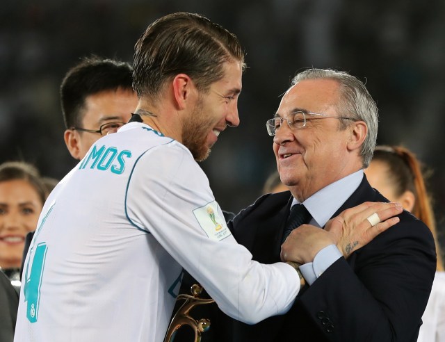 Real Madrid's captain Sergio Ramos (L) shakes hands with Real Madrid's President Florentino Perez after they won the FIFA Club World Cup final football match against Gremio FBPA at the Zayed Sports City Stadium in Abu Dhabi on December 16, 2017. Real Madrid defeated Gremio 1-0 to lift the FIFA Club World Cup for the third time. / AFP PHOTO / KARIM SAHIB