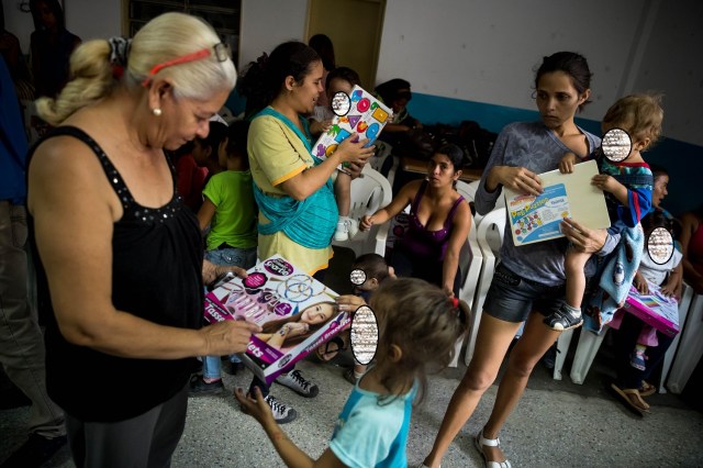 ACOMPAÑA CRÓNICA: VENEZUELA CRISIS. CAR10. CARACAS (VENEZUELA), 24/12/2017.- Niños reciben regalos de parte del Gobierno este viernes, 22 de diciembre de 2017, en una escuela pública al oeste de Caracas (Venezuela). El Niño Jesús no llevará regalos a muchos de los hogares de escasos recursos de Venezuela, pese a los millones de juguetes que el Gobierno de Nicolás Maduro ha asegurado que repartirá en todo el país, pues las familias dicen sentirse abandonadas y sumergidas en la crisis económica y social. EFE/Miguel Gutiérrez