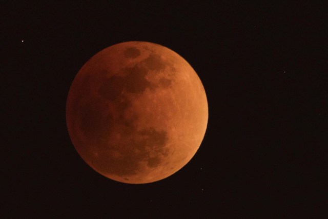 The moon is seen during a lunar eclipse, referred to as the "super blue blood moon", in Beijing on January 31, 2018. Skywatchers were hoping for a rare lunar eclipse that combines three unusual events -- a blue moon, a super moon and a total eclipse -- which was to make for a large crimson moon viewable in many corners of the globe. / AFP PHOTO / NICOLAS ASFOURI