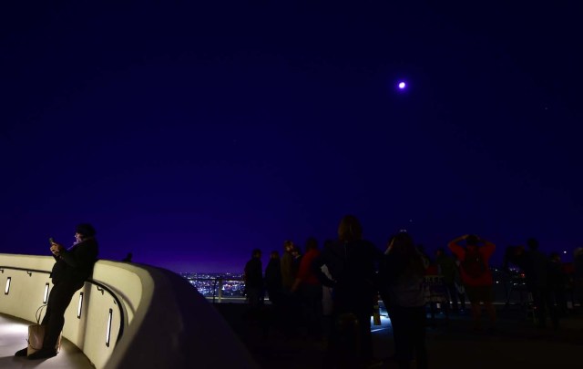 People attend the lunar eclipse celebration at Griffith Observatory in Los Angeles, California in the early hours of January 31, 2018, to witness the Super Blue Blood Moon, an event not seen since 1866 where three fairly common lunar happenings occur at the same time. Stargazers across large swathes of the globe -- from the streets of Los Angeles to the slopes of a smouldering Philippine volcano -- had the chance to witness a rare "super blue blood Moon" Wednesday, when Earth's shadow bathed our satellite in a coppery hue.The celestial show is the result of the Sun, Earth, and Moon lining up perfectly for a lunar eclipse just as the Moon is near its closest orbit point to Earth, making it appear "super" large. / AFP PHOTO / Frederic J. BROWN