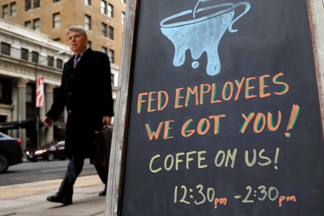 A worker passes a cafe offering free coffee to federal employees near the White House during the government shutdown in Washington, U.S., January 22, 2018. REUTERS/Kevin Lamarque