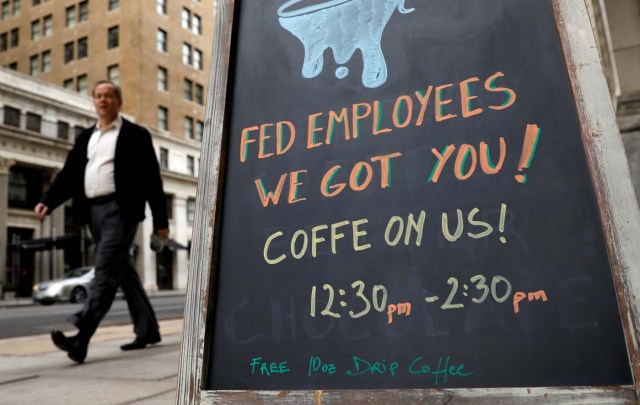A worker passes a cafe offering free coffee to federal employees near the the White House during the government shutdown in Washington, U.S., January 22, 2018. REUTERS/Kevin Lamarque