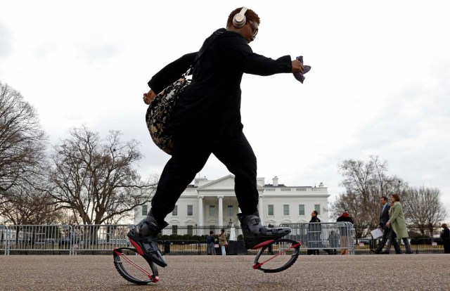 Wearing Kangoo jump boots, federal worker Tameka Green passes the White House as she exercises on her way to work during the government shutdown in Washington, U.S., January 22, 2018. REUTERS/Kevin Lamarque