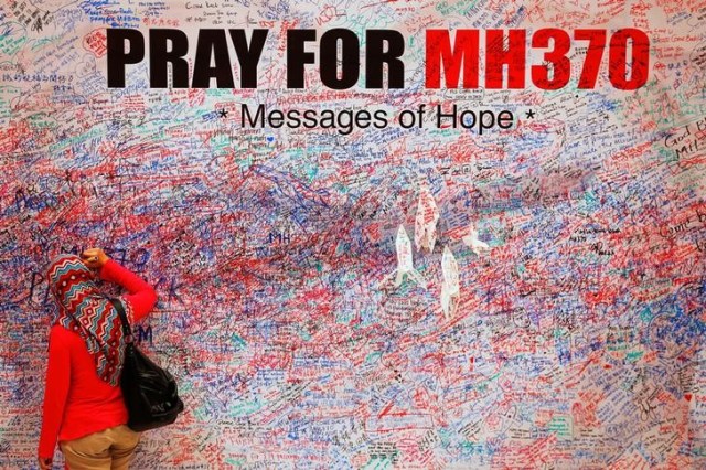 Una mujer deja un mensaje de apoyo y esperanza para los pasajeros del desaparecido Malaysia Airlines MH370 en el centro de Kuala Lumpur el 16 de marzo de 2014. REUTERS / Damir Sagolj / File Photo