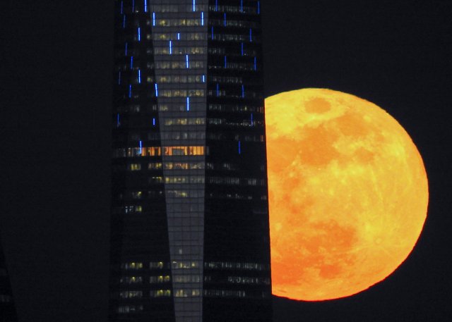 A full moon "supermoon" rises next to a skyscraper in Madrid, Spain, January 31, 2018.  REUTERS/Paul Hanna