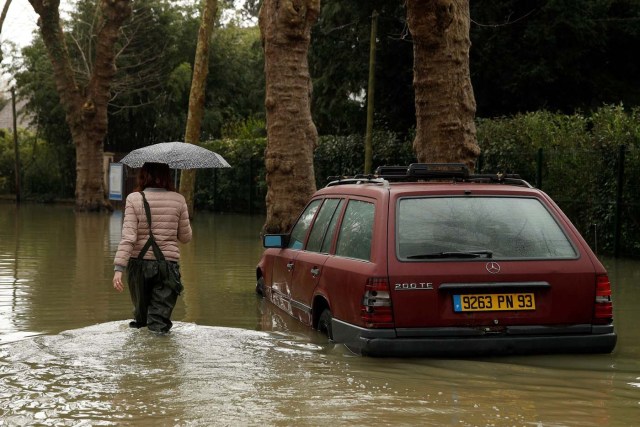 VAL107. VILLENNES SUR SEINE (FRANCIA), 30/01/2018.- Una mujer camina por una calle durante las inundaciones del río Sena a su paso por Villennes Sur Seine (Francia) hoy, 30 de enero de 2018. Las numerosas lluvias han provocado la crecida del Sena hasta causar inundaciones en París y sus alrededores. EFE/ Yoan Valat