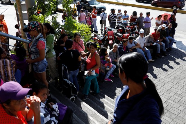 La gente espera en fila para comprar comida, en una acera frente a un supermercado en Caracas, Venezuela, el 6 de enero de 2018. REUTERS / Marco Bello