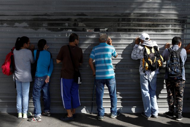 La gente se agolpa en las puertas de un supermercado mientras esperan para comprar comida en Caracas, Venezuela, el 6 de enero de 2018. REUTERS / Marco Bello