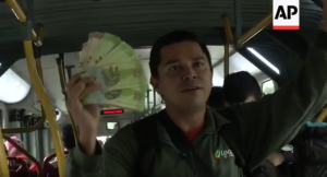 Venezolanos obsequian billetes a cambio de limosnas en autobuses de Bogotá (Video)