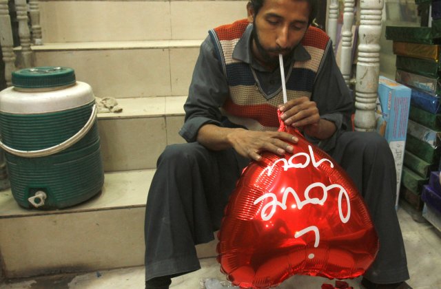 Un hombre infla un globo en forma de corazón antes del día de San Valentín en Peshawar, Pakistán, el 7 de febrero de 2018. REUTERS / Fayaz Aziz