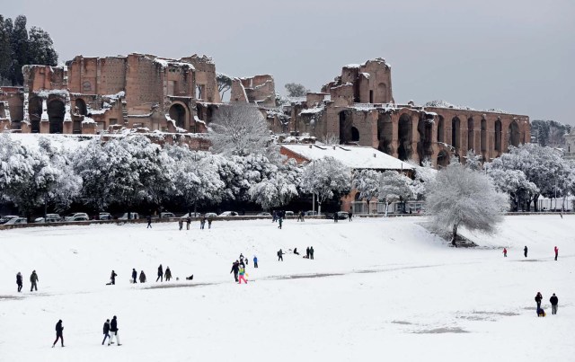 People walk during a heavy snowfall at the Circus Maximus in Rome, Italy February 26, 2018. REUTERS/Yara Nardi