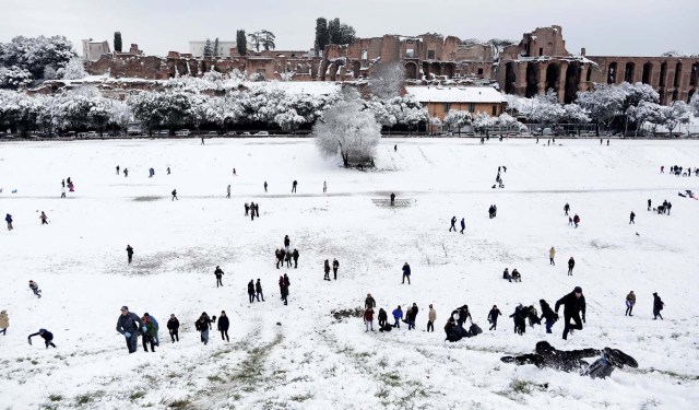 People walk during a heavy snowfall, at the Circus Maximus, in Rome, Italy February 26, 2018. REUTERS/Yara Nardi