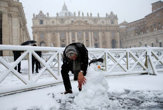 A man makes a snowman during a heavy snowfall in Saint Peter's Square at the Vatican February 26, 2018. REUTERS/Max Rossi