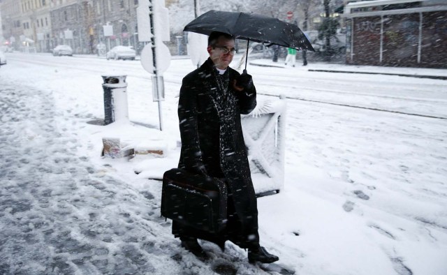 A priest walks during a heavy snowfall in Rome, Italy February 26, 2018. REUTERS/Max Rossi