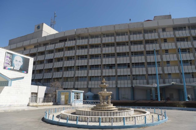 This photograph taken on March 7, 2018 shows a facade of the Intercontinental Hotel with an image of Afghan President Ashraf Ghani, in Kabul. Richard Clayderman's sweet-sounding "Romeo and Juliet" piano music accompanied Taliban gunmen as they rode in gold mirrored elevators to the upper floors of a Kabul luxury hotel in January in search of foreign guests to kill. At least 25 people, including 15 foreigners, were killed. Nearly seven weeks on, AFP was allowed to inspect the still badly damaged hilltop hotel overlooking the Afghan capital as it partially reopened its doors to the reluctant public. / AFP PHOTO / SHAH MARAI / TO GO WITH 'AFGHANISTAN-UNREST-HOTEL' SCENE by ALLISON JACKSON and EMAL HAIDARY