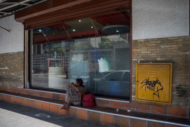 Fotografía del 3 de marzo de 2018 de un adolescente en la entrada de una panadería en Caracas (Venezuela). La inédita crisis económica y social de Venezuela se hace inocultable en calles y casas de abrigo que a diario reciben a niños que han quedado desamparados después de que sus padres emigraran a otro país a buscar nuevas formas de ingresos y los dejaran a cargo de personas que no pueden mantenerlos. EFE/MIGUEL GUTIÉRREZ