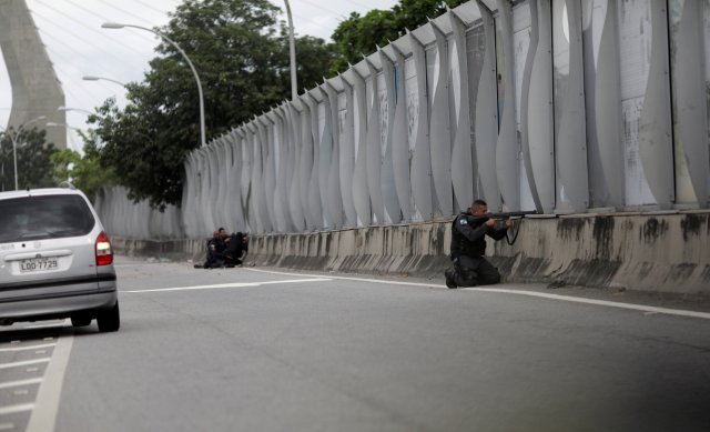 Policemen take up positions during an operation against drug dealers near the Mare slum complex in Rio de Janeiro, Brazil February 6, 2018. REUTERS/Ricardo Moraes