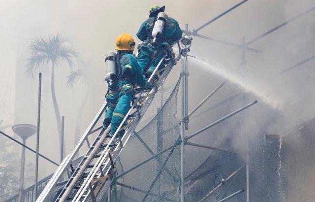 Firefighters douse water after a fire engulfed the Manila Pavilon hotel in Metro Manila, Philippines March 18, 2018. REUTERS/Romeo Ranoco