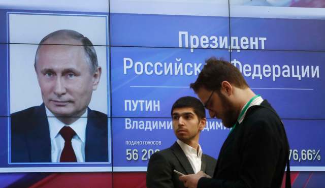 Hombres frente a una pantalla que muestra los resultados preliminares del presidente ruso, Vladimir Putin, en las elecciones presidenciales, en la sede de la Comisión Electoral Central de Rusia en Moscú, Rusia, el 19 de marzo de 2018. REUTERS / Sergei Karpukhin