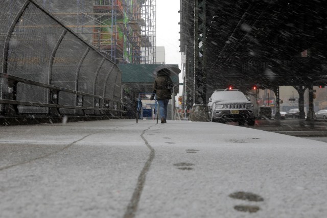 A pedestrian walks through a late season snow storm in New York, U.S., March 21, 2018. REUTERS/Lucas Jackson