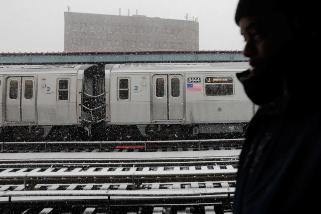 A commuter waits to catch the train during a late season snow storm in New York, U.S., March 21, 2018. REUTERS/Lucas Jackson