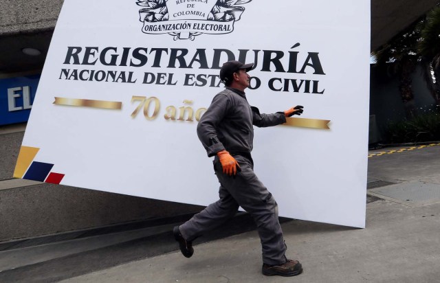 BOG120. BOGOTÁ (COLOMBIA), 10/03/2018.- Un trabajador instala un aviso de la Registraduría Nacional del Estado Civil hoy, sábado 10 de marzo de 2018, en vísperas de las elecciones legislativas, en Bogotá (Colombia). Este domingo, 36 millones de colombianos están llamados a las urnas para renovar la Cámara de Representantes y el Senado. EFE/Mauricio Dueñas Castañeda