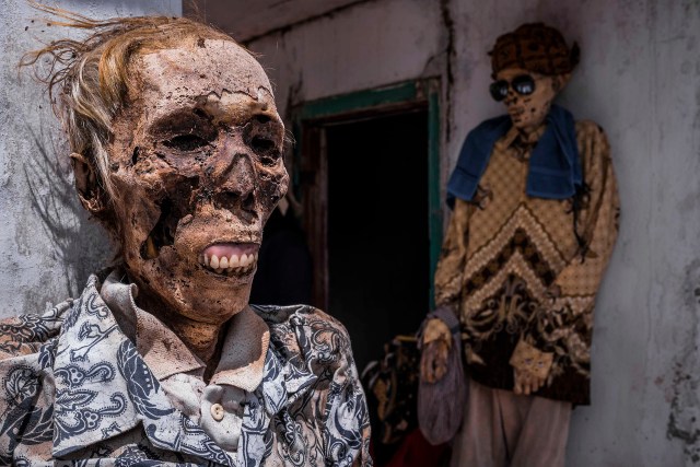 PIC BY Claudio Sieber / CATERS NEWS - (PICTURED one of the bodies)THESE images show a unique insight into the village where the living dig up their dead relatives to clean their bones and to dress them up. The dead can even remain in homes for decades until the family throw a huge party in their honour. The corpses are treated as sick until they finally find peace after funeral rites known as Rambu Solo The bizarre ritual was pictured in South Sulawesi, Indonesia, where even buried relatives are taken out of their coffins for new outfits and a bone polish. SEE CATERS COPY