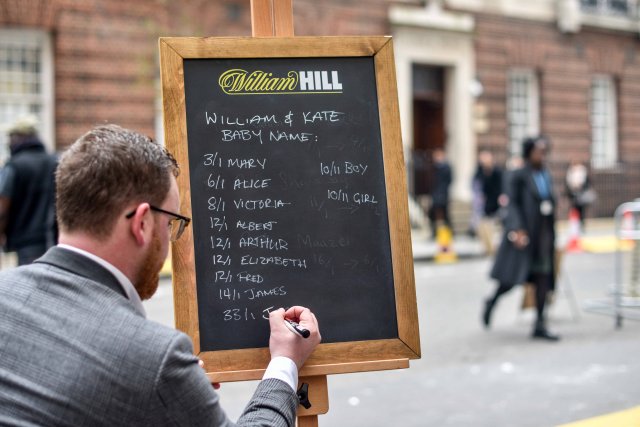 Joe Crilly, a spokesperson from the bookmaker William Hill, writes the names and betting odds for the third royal baby of Britain's Prince William and Catherine, Duchess of Cambridge, on a board outside the Lindo Wing St Mary's Hospital in west London, Britain, April 13, 2018. REUTERS/Peter Summers