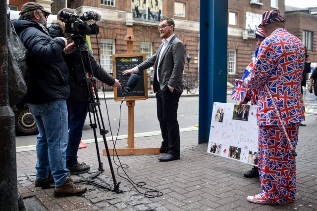 Joe Crilly, a spokesperson from the bookmaker William Hill, is interviewed by a televsion crew as he writes the names and betting odds for the third royal baby of Britain's Prince William and Catherine, Duchess of Cambridge, on a board outside the Lindo Wing St Mary's Hospital in west London, Britain, April 13, 2018. REUTERS/Peter Summers
