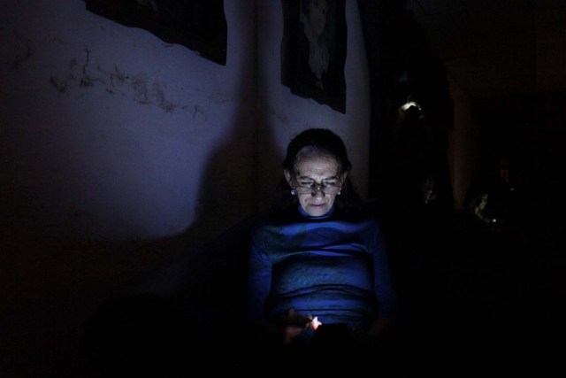 Carmenza Herrera uses her cellphone during a blackout in San Cristobal, Venezuela, April 19, 2018. Picture taken April 19, 2018. REUTERS/Carlos Eduardo Ramirez