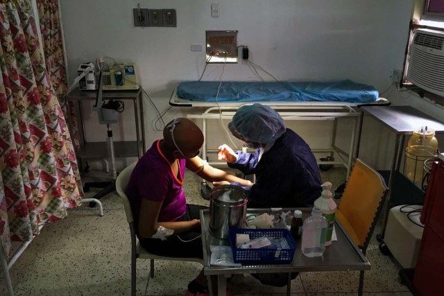 A girl is assisted by a nurse at the chemotherapy room of the "Dr. JM de los Rios" Children's Hospital in Caracas on April 10, 2018. The crisis in Venezuela has hit children's health, with an increase of 30,12% in child mortality according to the most recent official sources. / AFP PHOTO / FEDERICO PARRA