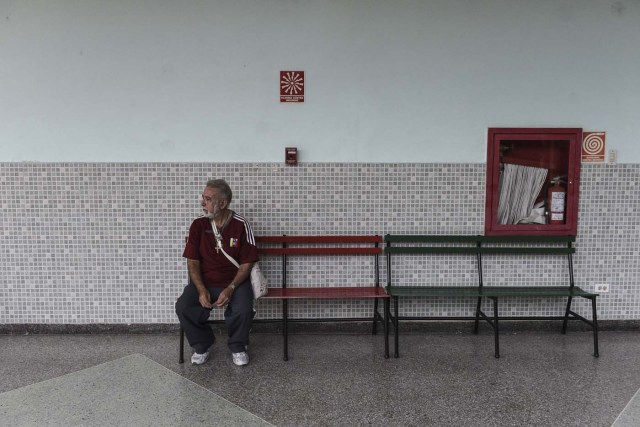 A Venezuelan man waits at an empty polling station during the presidential elections in Caracas on May 20, 2018 Venezuelans, reeling under a devastating economic crisis, began voting Sunday in an election boycotted by the opposition and condemned by much of the international community but expected to hand deeply unpopular President Nicolas Maduro a new mandate / AFP PHOTO / Carlos Becerra
