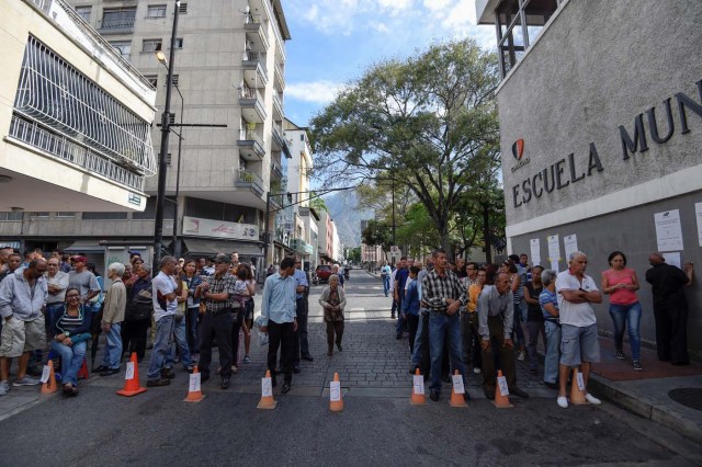 Venezuelans queue outside a polling station as they wait to cast their vote during the presidential elections in Caracas on May 20, 2018 Venezuelans, reeling under a devastating economic crisis, began voting Sunday in an election boycotted by the opposition and condemned by much of the international community but expected to hand deeply unpopular President Nicolas Maduro a new mandate / AFP PHOTO / Juan BARRETO
