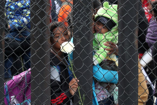Miembros de una caravana de migrantes de América Central y sus simpatizantes miran a través de la barrera fronteriza que separa a Estados Unidos y México en el parque estatal Border Field antes de solicitar asilo, en San Diego, Estados Unidos, 29 de abril del 2018. REUTERS/Lucy Nicholson